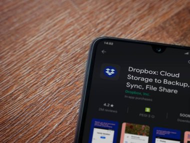 Lod, Israel - 8 Temmuz 2020: Dropbox uygulaması oyun mağazası sayfası ahşap arka planda siyah bir cep telefonunun ekranında. Üst görünüm düzlüğü kopyalama alanı ile yatıyordu.