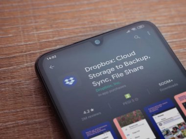 Lod, Israel - 8 Temmuz 2020: Dropbox uygulaması oyun mağazası sayfası ahşap arka planda siyah bir cep telefonunun ekranında. Üst görünüm düzlüğü kopyalama alanı ile yatıyordu.
