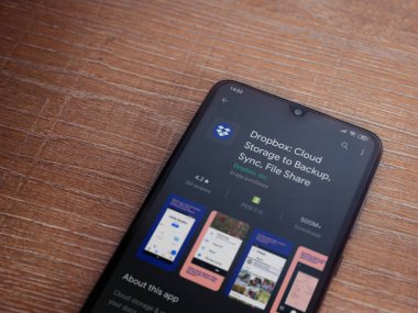 Lod, Israel - 8 Temmuz 2020: Dropbox uygulaması oyun mağazası sayfası ahşap arka planda siyah bir cep telefonunun ekranında. Üst görünüm düzlüğü kopyalama alanı ile yatıyordu.