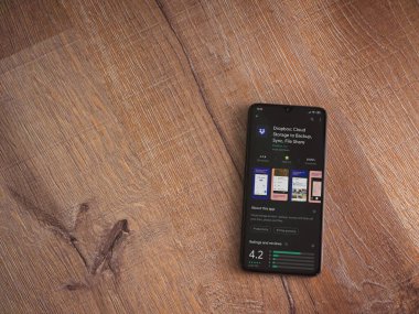 Lod, Israel - 8 Temmuz 2020: Dropbox uygulaması oyun mağazası sayfası ahşap arka planda siyah bir cep telefonunun ekranında. Üst görünüm düzlüğü kopyalama alanı ile yatıyordu.