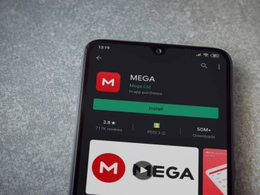 Lod, Israel - 8 Temmuz 2020: MeGA uygulama oyun mağazası sayfası seramik taş zemin üzerinde siyah bir cep telefonu görüntüsü. Üst görünüm düzlüğü kopyalama alanı ile yatıyordu.
