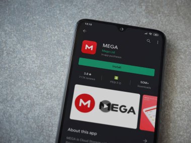 Lod, Israel - 8 Temmuz 2020: MeGA uygulama oyun mağazası sayfası seramik taş zemin üzerinde siyah bir cep telefonu görüntüsü. Üst görünüm düzlüğü kopyalama alanı ile yatıyordu.