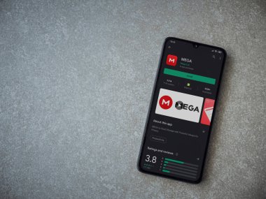 Lod, Israel - 8 Temmuz 2020: MeGA uygulama oyun mağazası sayfası seramik taş zemin üzerinde siyah bir cep telefonu görüntüsü. Üst görünüm düzlüğü kopyalama alanı ile yatıyordu.