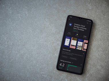 Lod, Israel - 8 Temmuz 2020: Seramik taş zemin üzerinde siyah bir cep telefonu ekranında Dropbox uygulaması oyun mağazası sayfası. Üst görünüm düzlüğü kopyalama alanı ile yatıyordu.