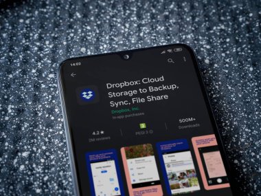 Lod, Israel - 8 Temmuz 2020: Metalik arka planda siyah bir cep telefonunun sergilendiği Dropbox uygulaması oyun mağazası sayfası. Üst görünüm yatağını kapat.