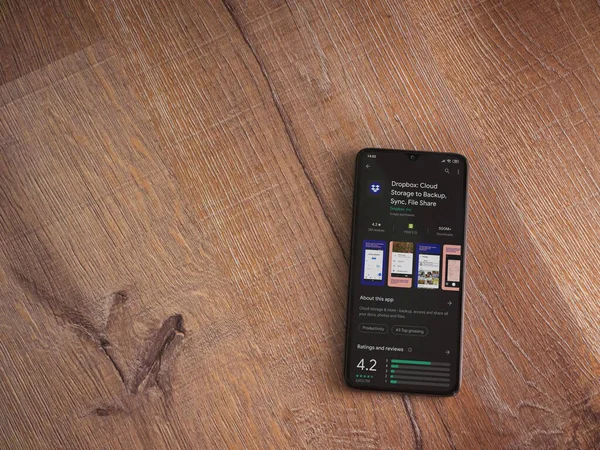 Lod, Israel - 8 Temmuz 2020: Dropbox uygulaması oyun mağazası sayfası ahşap arka planda siyah bir cep telefonunun ekranında. Üst görünüm düzlüğü kopyalama alanı ile yatıyordu.