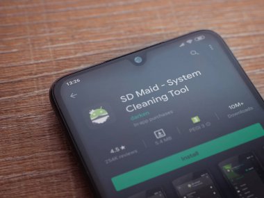 Lod, Israel - 8 Temmuz 2020: SD Maid uygulaması oyun mağazası sayfası ahşap arka planda siyah bir cep telefonu sergilenmektedir. Üst görünüm düzlüğü kopyalama alanı ile yatıyordu.