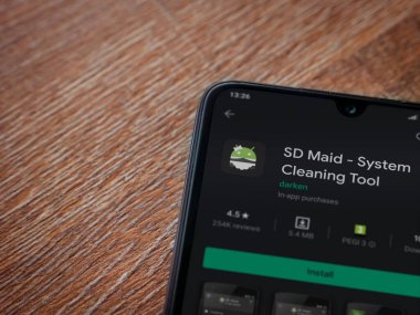 Lod, Israel - 8 Temmuz 2020: SD Maid uygulaması oyun mağazası sayfası ahşap arka planda siyah bir cep telefonu sergilenmektedir. Üst görünüm düzlüğü kopyalama alanı ile yatıyordu.