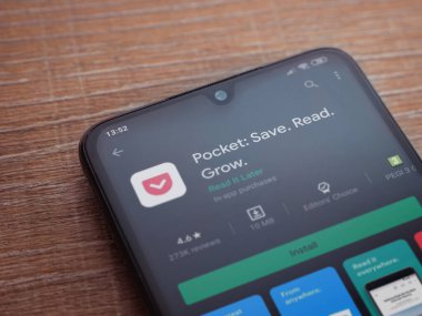 Lod, Israel - 8 Temmuz 2020: Cep telefonu uygulaması oyun mağazası sayfası ahşap arka planda siyah bir cep telefonu ekranında. Üst görünüm düzlüğü kopyalama alanı ile yatıyordu.