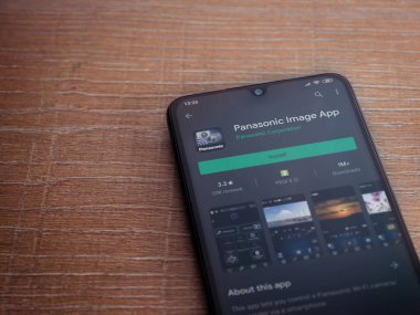 Lod, Israel - 8 Temmuz 2020: Panasonic Image App uygulama oyun mağazası sayfası ahşap arka planda siyah bir cep telefonu görüntüsü. Üst görünüm düzlüğü kopyalama alanı ile yatıyordu.