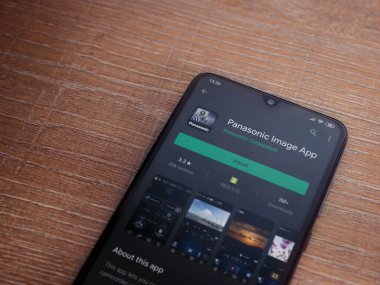 Lod, Israel - 8 Temmuz 2020: Panasonic Image App uygulama oyun mağazası sayfası ahşap arka planda siyah bir cep telefonu görüntüsü. Üst görünüm düzlüğü kopyalama alanı ile yatıyordu.