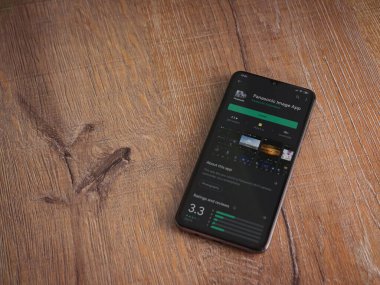 Lod, Israel - 8 Temmuz 2020: Panasonic Image App uygulama oyun mağazası sayfası ahşap arka planda siyah bir cep telefonu görüntüsü. Üst görünüm düzlüğü kopyalama alanı ile yatıyordu.