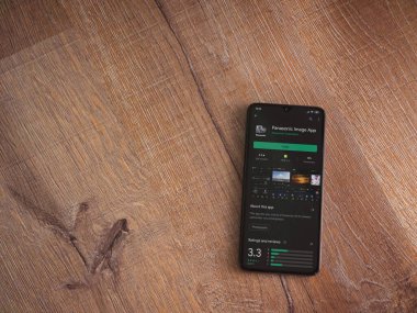 Lod, Israel - 8 Temmuz 2020: Panasonic Image App uygulama oyun mağazası sayfası ahşap arka planda siyah bir cep telefonu görüntüsü. Üst görünüm düzlüğü kopyalama alanı ile yatıyordu.