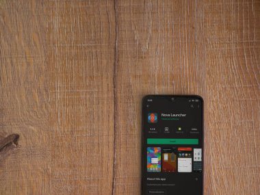 Lod, Israel - 8 Temmuz 2020: Nova Launcher uygulaması oyun mağazası sayfası ahşap arka planda siyah bir cep telefonu ekranında. Üst görünüm düzlüğü kopyalama alanı ile yatıyordu.