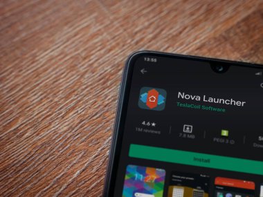 Lod, Israel - 8 Temmuz 2020: Nova Launcher uygulaması oyun mağazası sayfası ahşap arka planda siyah bir cep telefonu ekranında. Üst görünüm düzlüğü kopyalama alanı ile yatıyordu.