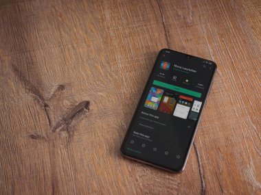 Lod, Israel - 8 Temmuz 2020: Nova Launcher uygulaması oyun mağazası sayfası ahşap arka planda siyah bir cep telefonu ekranında. Üst görünüm düzlüğü kopyalama alanı ile yatıyordu.