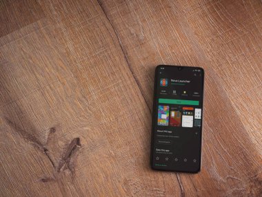 Lod, Israel - 8 Temmuz 2020: Nova Launcher uygulaması oyun mağazası sayfası ahşap arka planda siyah bir cep telefonu ekranında. Üst görünüm düzlüğü kopyalama alanı ile yatıyordu.