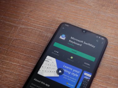 Lod, Israel - 8 Temmuz 2020: Microsoft SwiftKey Klavye uygulama oyun sayfası ahşap arka planda siyah bir cep telefonu ekranında. Üst görünüm düzlüğü kopyalama alanı ile yatıyordu.