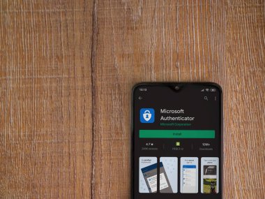 Lod, Israel - 8 Temmuz 2020: Microsoft Authenticator uygulama oyun mağazası sayfası ahşap arka planda siyah bir cep telefonu ekranında. Üst görünüm düzlüğü kopyalama alanı ile yatıyordu.