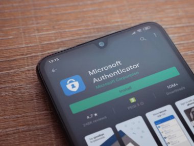 Lod, Israel - 8 Temmuz 2020: Microsoft Authenticator uygulama oyun mağazası sayfası ahşap arka planda siyah bir cep telefonu ekranında. Üst görünüm düzlüğü kopyalama alanı ile yatıyordu.