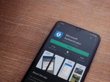Lod, Israel - 8 Temmuz 2020: Microsoft Authenticator uygulama oyun mağazası sayfası ahşap arka planda siyah bir cep telefonu ekranında. Üst görünüm düzlüğü kopyalama alanı ile yatıyordu.