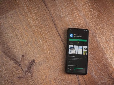 Lod, Israel - 8 Temmuz 2020: Microsoft Authenticator uygulama oyun mağazası sayfası ahşap arka planda siyah bir cep telefonu ekranında. Üst görünüm düzlüğü kopyalama alanı ile yatıyordu.