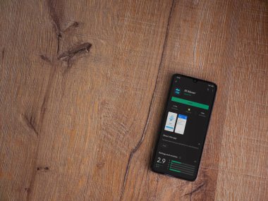 Lod, Israel - 8 Temmuz 2020: Mi Mover uygulama oyun mağazası sayfası ahşap arka planda siyah bir cep telefonunun ekranında. Üst görünüm düzlüğü kopyalama alanı ile yatıyordu.