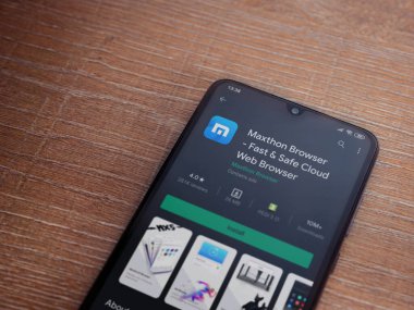 Lod, Israel - 8 Temmuz 2020: Maxthon Browser uygulama oyun mağazası sayfası ahşap arka planda siyah bir cep telefonunun ekranında. Üst görünüm düzlüğü kopyalama alanı ile yatıyordu.