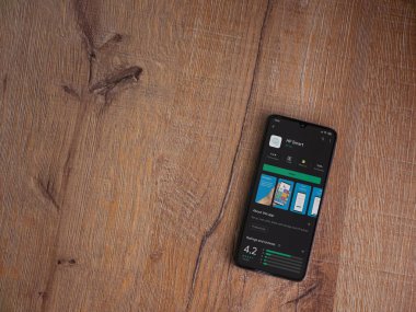 Lod, Israel - 8 Temmuz 2020: HP Smart uygulama oyun mağazası sayfası ahşap arka planda siyah bir cep telefonunun ekranında. Üst görünüm düzlüğü kopyalama alanı ile yatıyordu.