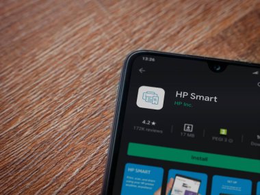 Lod, Israel - 8 Temmuz 2020: HP Smart uygulama oyun mağazası sayfası ahşap arka planda siyah bir cep telefonunun ekranında. Üst görünüm düzlüğü kopyalama alanı ile yatıyordu.