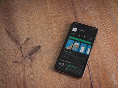 Lod, Israel - 8 Temmuz 2020: HP Smart uygulama oyun mağazası sayfası ahşap arka planda siyah bir cep telefonunun ekranında. Üst görünüm düzlüğü kopyalama alanı ile yatıyordu.