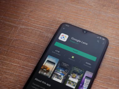 Lod, Israel - 8 Temmuz 2020: Google Lens uygulama oyun mağazası sayfası ahşap arka planda siyah bir cep telefonu ekranında. Üst görünüm düzlüğü kopyalama alanı ile yatıyordu.