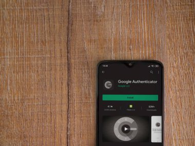 Lod, Israel - 8 Temmuz 2020: Google Authenticator uygulaması oyun mağazası sayfası ahşap arka planda siyah bir cep telefonu ekranında. Üst görünüm düzlüğü kopyalama alanı ile yatıyordu.