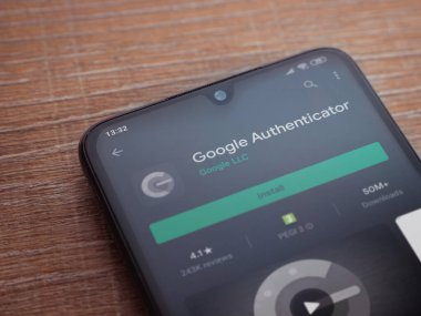 Lod, Israel - 8 Temmuz 2020: Google Authenticator uygulaması oyun mağazası sayfası ahşap arka planda siyah bir cep telefonu ekranında. Üst görünüm düzlüğü kopyalama alanı ile yatıyordu.