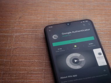 Lod, Israel - 8 Temmuz 2020: Google Authenticator uygulaması oyun mağazası sayfası ahşap arka planda siyah bir cep telefonu ekranında. Üst görünüm düzlüğü kopyalama alanı ile yatıyordu.