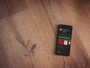 Lod, Israel - 8 Temmuz 2020: ExpressVPN uygulama oyun mağazası sayfası ahşap arka planda siyah bir cep telefonu ekranında. Üst görünüm düzlüğü kopyalama alanı ile yatıyordu.