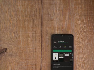 Lod, Israel - 8 Temmuz 2020: Menzil uygulaması oyun mağazası sayfası ahşap arka planda siyah bir cep telefonunun ekranında. Üst görünüm düzlüğü kopyalama alanı ile yatıyordu.