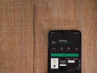 Lod, Israel - 8 Temmuz 2020: Menzil uygulaması oyun mağazası sayfası ahşap arka planda siyah bir cep telefonunun ekranında. Üst görünüm düzlüğü kopyalama alanı ile yatıyordu.