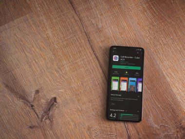 Lod, Israel - 8 Temmuz 2020: Küp ACR uygulama oyun mağazası sayfası ahşap arka planda siyah bir cep telefonunun ekranında. Üst görünüm düzlüğü kopyalama alanı ile yatıyordu.