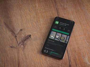 Lod, Israel - 8 Temmuz 2020: Airdroid uygulama oyun mağazası sayfası ahşap arka planda siyah bir cep telefonunun ekranında. Üst görünüm düzlüğü kopyalama alanı ile yatıyordu.