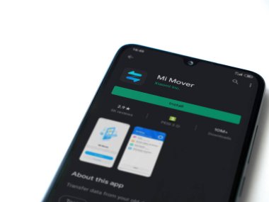 Lod, Israel - 8 Temmuz 2020: Mi Mover uygulaması oyun mağazası sayfası beyaz arkaplanda izole edilmiş siyah bir cep telefonu ekranında. Üst görünüm düzlüğü kopyalama alanı ile yatıyordu.