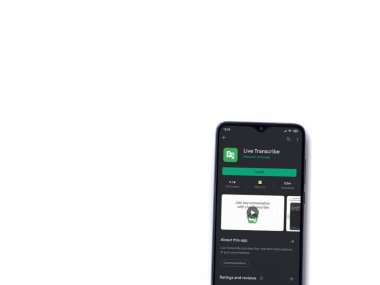 Lod, Israel - 8 Temmuz 2020: Beyaz arkaplanda izole edilmiş siyah bir cep telefonunun ekranında Live Transcribe uygulaması oyun mağazası sayfası. Üst görünüm düzlüğü kopyalama alanı ile yatıyordu.