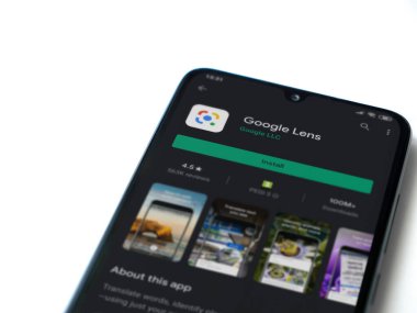 Lod, Israel - 8 Temmuz 2020: Google Lens uygulaması oyun mağazası sayfası beyaz arkaplanda izole edilmiş siyah bir cep telefonu ekranında. Üst görünüm düzlüğü kopyalama alanı ile yatıyordu.