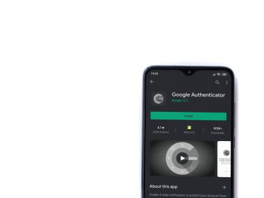 Lod, Israel - 8 Temmuz 2020: Google Authenticator uygulama oyun mağazası sayfası beyaz arkaplanda izole edilmiş siyah bir cep telefonu ekranında. Üst görünüm düzlüğü kopyalama alanı ile yatıyordu.