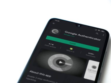 Lod, Israel - 8 Temmuz 2020: Google Authenticator uygulama oyun mağazası sayfası beyaz arkaplanda izole edilmiş siyah bir cep telefonu ekranında. Üst görünüm düzlüğü kopyalama alanı ile yatıyordu.