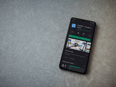 Lod, Israel - 8 Temmuz 2020: Seramik taş zemin üzerinde siyah bir cep telefonunun sergilendiği SHAREit uygulaması oyun mağazası sayfası. Üst görünüm düzlüğü kopyalama alanı ile yatıyordu.
