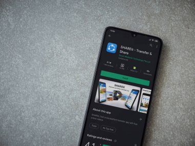Lod, Israel - 8 Temmuz 2020: Seramik taş zemin üzerinde siyah bir cep telefonunun sergilendiği SHAREit uygulaması oyun mağazası sayfası. Üst görünüm düzlüğü kopyalama alanı ile yatıyordu.