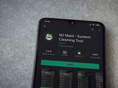 Lod, Israel - 8 Temmuz 2020: SD Maid uygulaması oyun mağazası sayfası seramik taş zemin üzerinde siyah bir cep telefonu görüntüsü. Üst görünüm düzlüğü kopyalama alanı ile yatıyordu.
