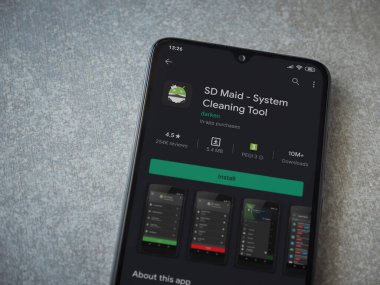Lod, Israel - 8 Temmuz 2020: SD Maid uygulaması oyun mağazası sayfası seramik taş zemin üzerinde siyah bir cep telefonu görüntüsü. Üst görünüm düzlüğü kopyalama alanı ile yatıyordu.