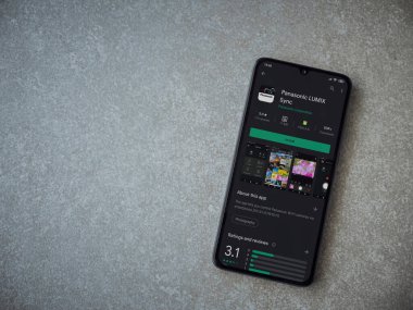 Lod, Israel - 8 Temmuz 2020: Panasonic LUMIX Sync uygulama oyun mağazası sayfası seramik taş zemin üzerinde siyah bir cep telefonu görüntüsü. Üst görünüm düzlüğü kopyalama alanı ile yatıyordu.